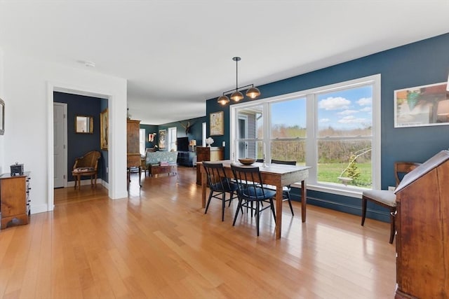 dining space with baseboards and light wood-type flooring