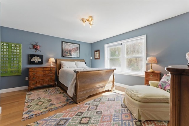 bedroom with baseboards and wood finished floors
