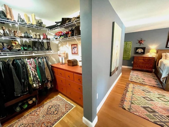 walk in closet with wood finished floors