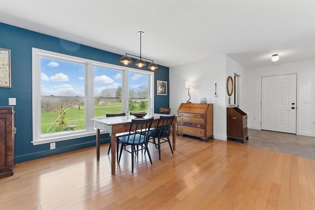 dining room featuring baseboards and light wood-style flooring