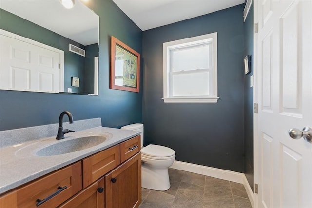 bathroom featuring visible vents, baseboards, toilet, and vanity