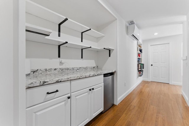 hall featuring visible vents, light wood-style floors, a wall mounted air conditioner, baseboards, and recessed lighting