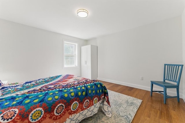 bedroom featuring baseboards and wood finished floors
