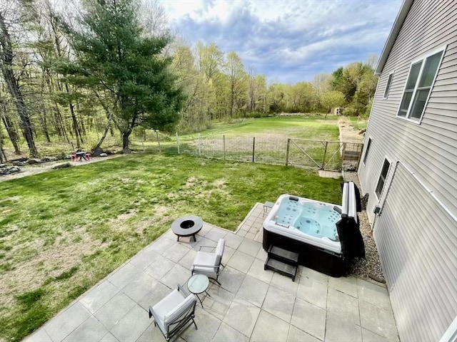 view of yard featuring a hot tub, fence, a wooded view, an outdoor fire pit, and a patio