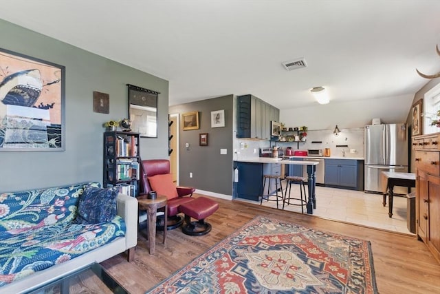 living area featuring visible vents and light wood-type flooring