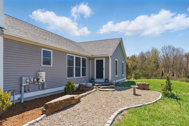exterior space with a lawn and a shingled roof