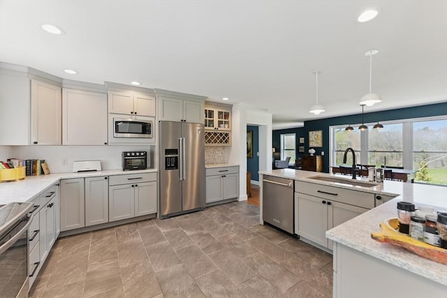 kitchen featuring decorative backsplash, decorative light fixtures, appliances with stainless steel finishes, a sink, and recessed lighting