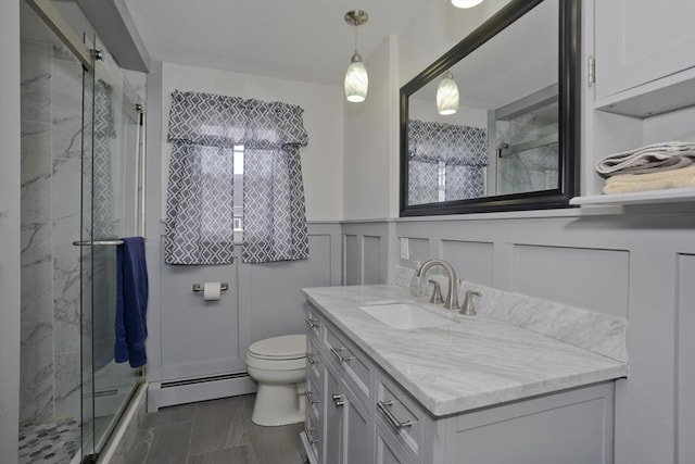 bathroom featuring toilet, baseboard heating, and a stall shower