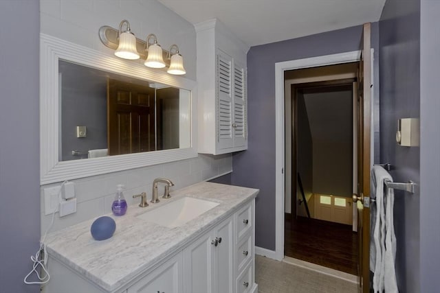 bathroom featuring vanity, baseboards, backsplash, and tile patterned flooring