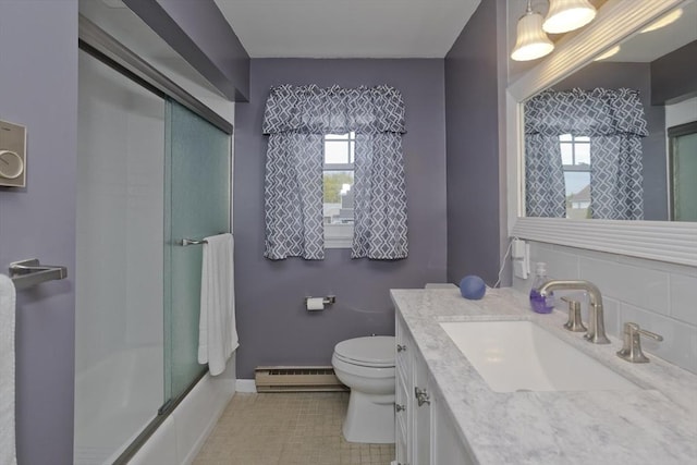 full bath featuring a wealth of natural light, a shower with door, baseboard heating, and toilet