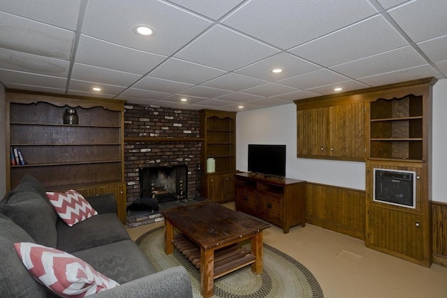 living area featuring recessed lighting, a fireplace, a drop ceiling, and built in shelves