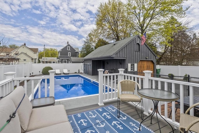 view of pool with a deck, a fenced in pool, an outbuilding, and a fenced backyard