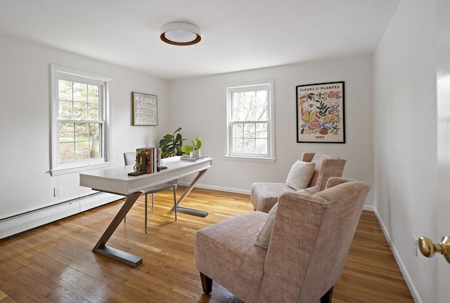 office area with plenty of natural light, wood finished floors, baseboards, and baseboard heating