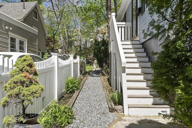 view of side of home with fence and stairs