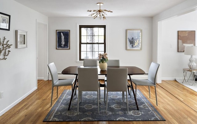 dining space with wood finished floors, baseboards, and a chandelier