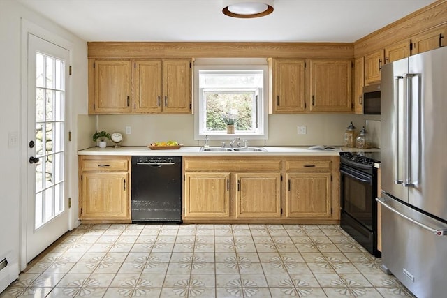 kitchen with black appliances, a sink, light countertops, and plenty of natural light