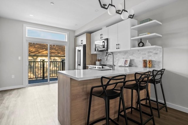 33 Copeland Unit F, Boston, MA 02119 - kitchen featuring stainless steel appliances, wood finished floors, decorative backsplash, light countertops, and open shelves