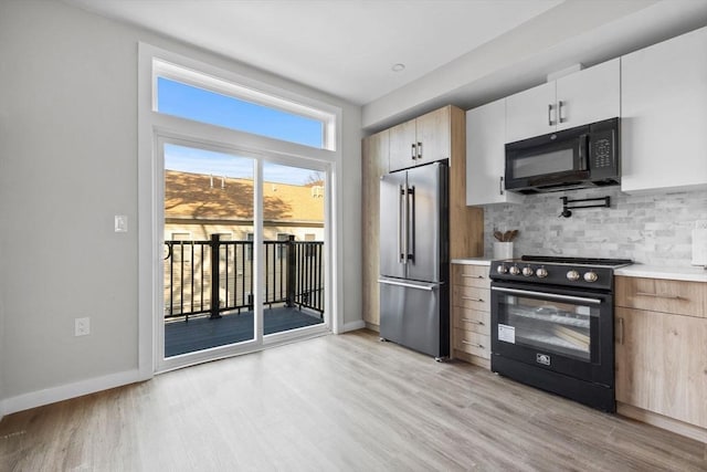 33 Copeland Unit F, Boston, MA 02119 - kitchen featuring black appliances, light wood-style floors, light countertops, and tasteful backsplash