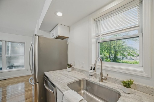 30 Balfour St, Boston, MA 02125 - kitchen featuring a sink, stainless steel appliances, white cabinetry, light stone counters, and light wood-type flooring
