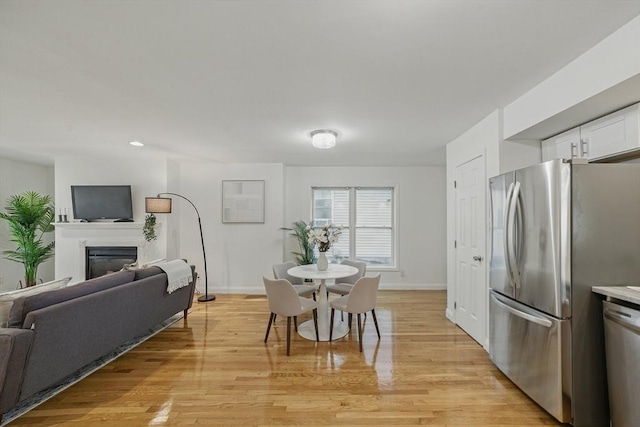 30 Balfour St, Boston, MA 02125 - dining space featuring light wood-style floors, a glass covered fireplace, and baseboards
