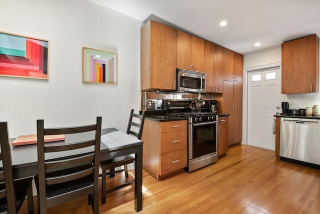 30 Edgerly Unit 4, Boston, MA 02115 - kitchen featuring appliances with stainless steel finishes, dark countertops, brown cabinetry, light wood-style floors, and recessed lighting