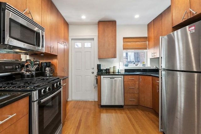 30 Edgerly Unit 4, Boston, MA 02115 - kitchen with appliances with stainless steel finishes, brown cabinetry, light wood-type flooring, dark countertops, and recessed lighting