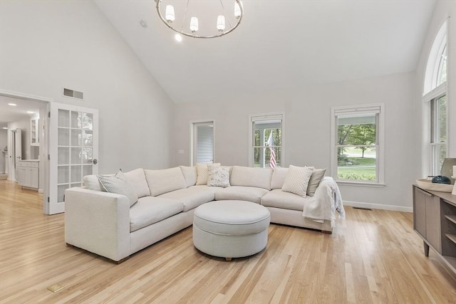 3 Misty Ln, Westford, MA 01886 - living area featuring high vaulted ceiling, a chandelier, healthy amount of natural light, light wood-style flooring, and baseboards