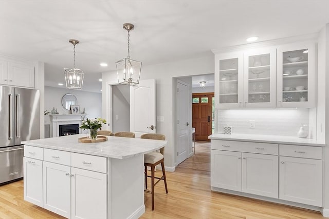3 Misty Ln, Westford, MA 01886 - kitchen featuring high end refrigerator, a breakfast bar area, white cabinetry, light countertops, and recessed lighting