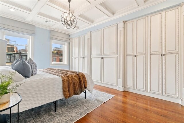 bedroom with light hardwood / wood-style floors, crown molding, beam ceiling, and coffered ceiling