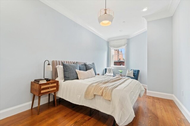 bedroom featuring ornamental molding and hardwood / wood-style floors