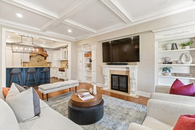 living room featuring coffered ceiling, a premium fireplace, light hardwood / wood-style flooring, and beamed ceiling