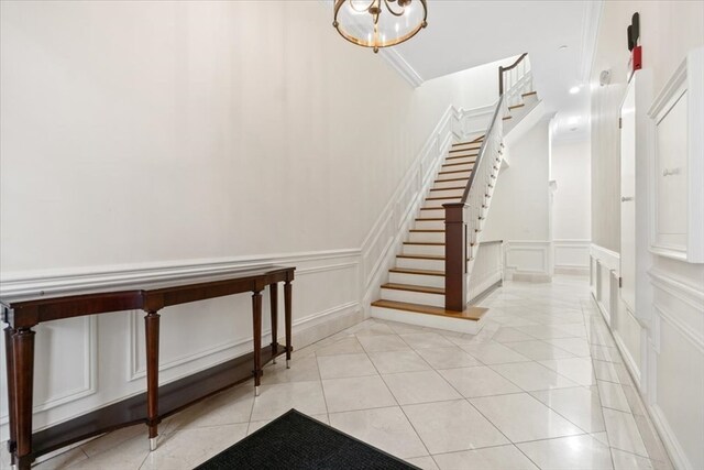 stairway with tile patterned floors and a chandelier