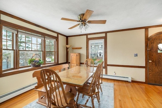 dining room featuring light wood finished floors, a ceiling fan, a baseboard radiator, and arched walkways