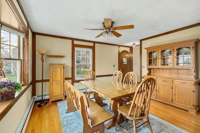 dining area with crown molding, light wood-style flooring, baseboard heating, and ceiling fan