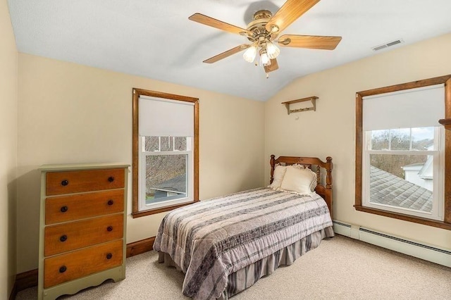 bedroom featuring a baseboard heating unit, visible vents, light colored carpet, and vaulted ceiling