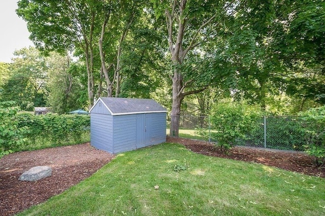 view of yard featuring an outdoor structure, a fenced backyard, and a storage unit