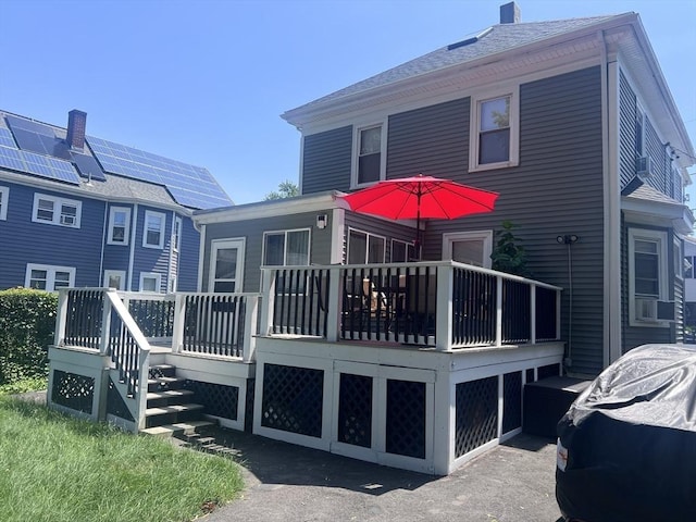81 Rockdale St, Boston, MA 02126 - rear view of house with a wooden deck, a chimney, and an attached garage