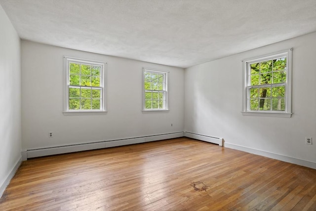 30 Juniper Cir, Concord, MA 01742 - empty room with light wood-type flooring, baseboards, and a baseboard heating unit
