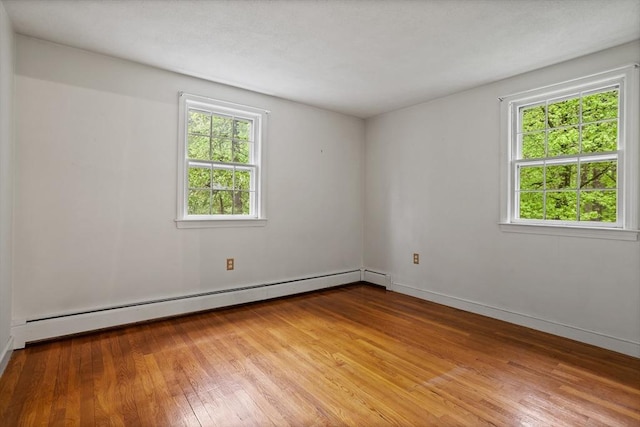 30 Juniper Cir, Concord, MA 01742 - unfurnished room with a baseboard heating unit, plenty of natural light, hardwood / wood-style flooring, and baseboards