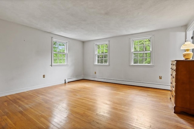 30 Juniper Cir, Concord, MA 01742 - empty room featuring hardwood / wood-style flooring, baseboards, a baseboard radiator, and a textured ceiling