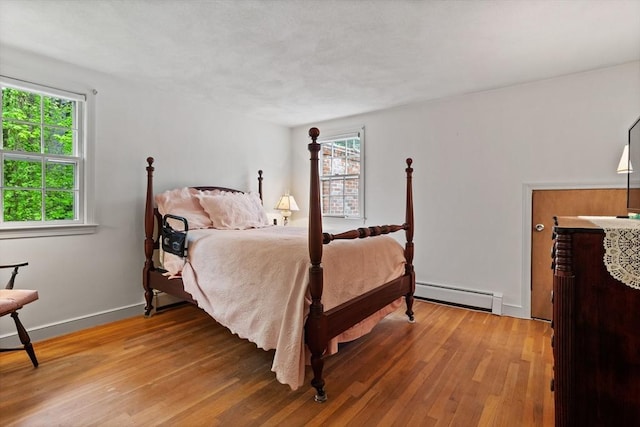 30 Juniper Cir, Concord, MA 01742 - bedroom with a baseboard radiator, multiple windows, and wood finished floors