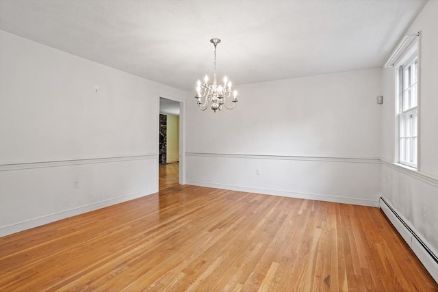 30 Juniper Cir, Concord, MA 01742 - empty room with a baseboard radiator, a chandelier, light wood-type flooring, and baseboards