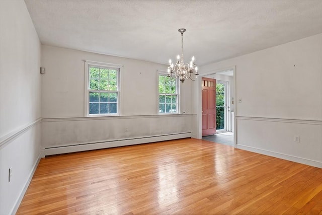 30 Juniper Cir, Concord, MA 01742 - spare room with baseboard heating, a chandelier, and wood finished floors