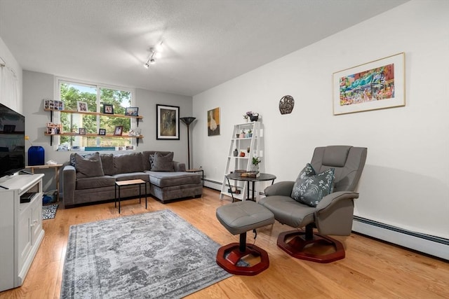 321 Harvard St Unit 302, Cambridge, MA 02139 - living area featuring light wood-type flooring, a textured ceiling, and a baseboard radiator