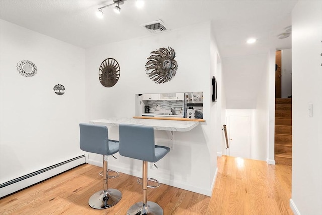 321 Harvard St Unit 302, Cambridge, MA 02139 - bar featuring a baseboard radiator, wood finished floors, and stairway