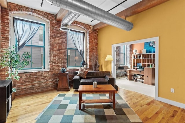 sitting room featuring light hardwood / wood-style floors and brick wall