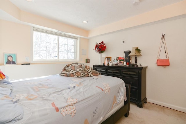 bedroom featuring light carpet and baseboards