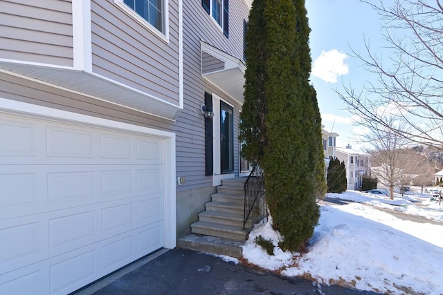 view of snow covered exterior featuring a garage