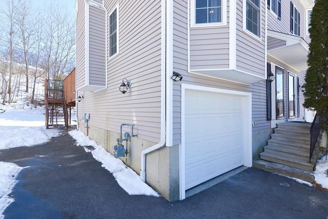 snow covered property featuring a garage