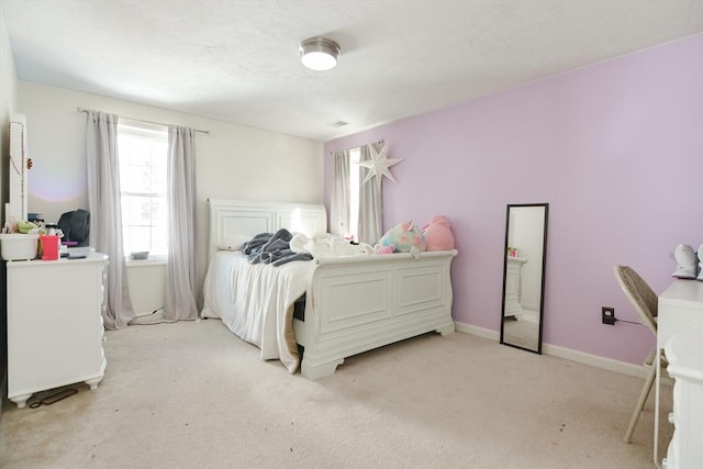 bedroom featuring light colored carpet and baseboards